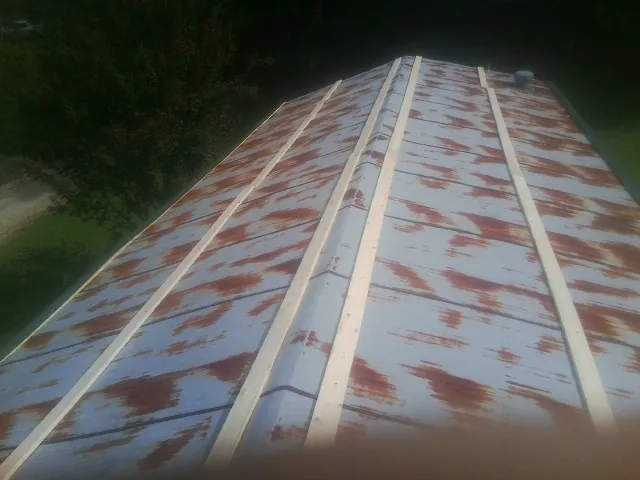 Rusted metal roof panels with new wood purlins before replacement — Storm Damage Roof Repair in Turner by Roofing Brothers