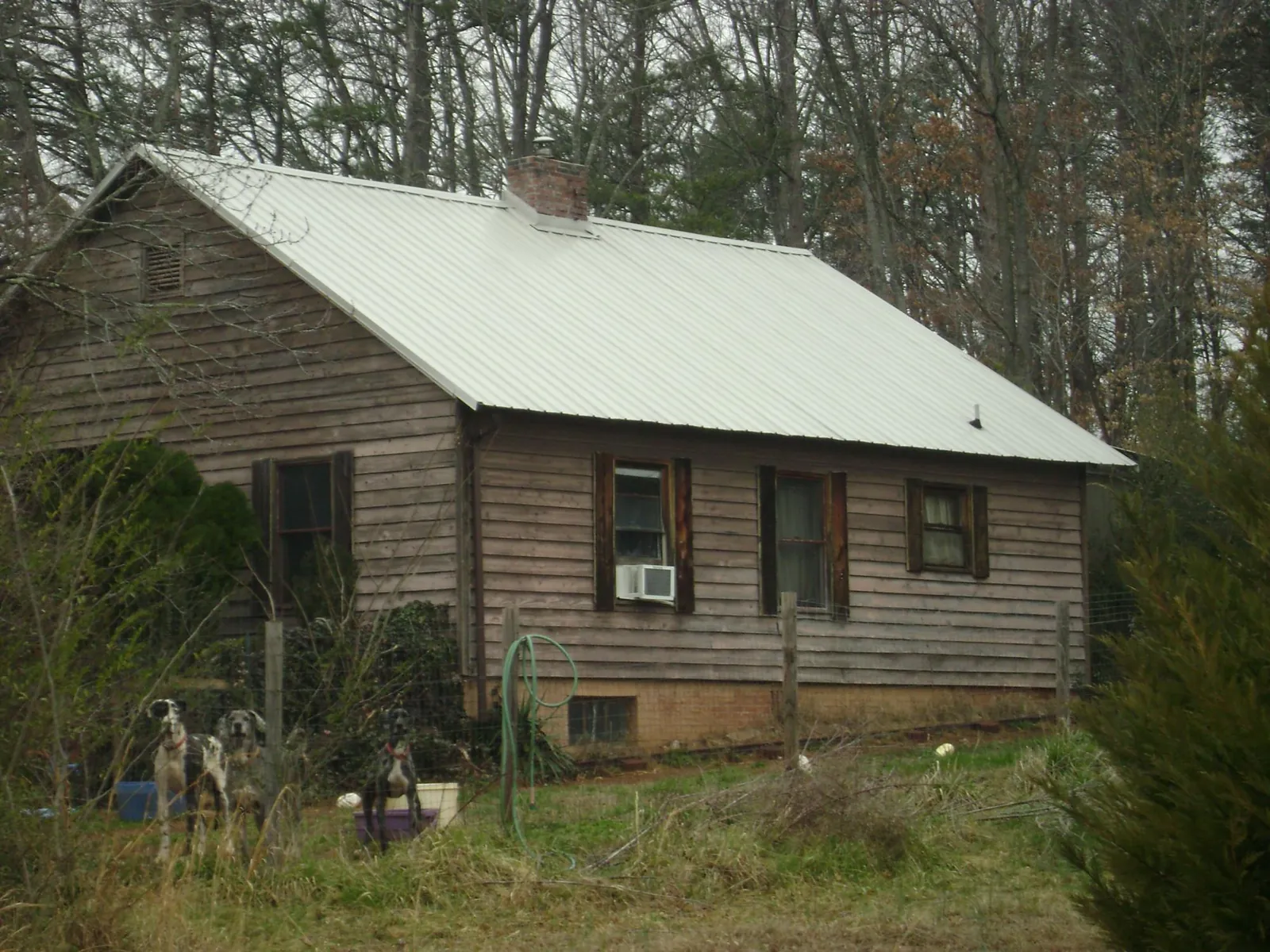 White metal roof on an old wood sided farmhouse, from a Metal Roof Installation job in Turner